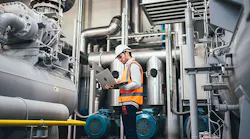 engineer-using-laptop-to-program-PLC-to-manage-large-machine
