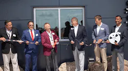 Photo-of-Chris-Lauer-Brian-Holmer-Rob-Stordahl-Dave-Doherty-Steve-Grove-and-Ramesh-Babu-cutting-digi-reel-in-front-of-new-distribution-center-building
