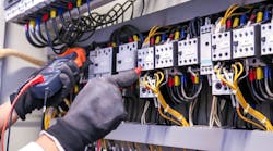 Hands testing connections at terminal block Hands testing connections at terminal block