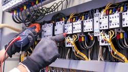 Hands testing connections at terminal block Hands testing connections at terminal block