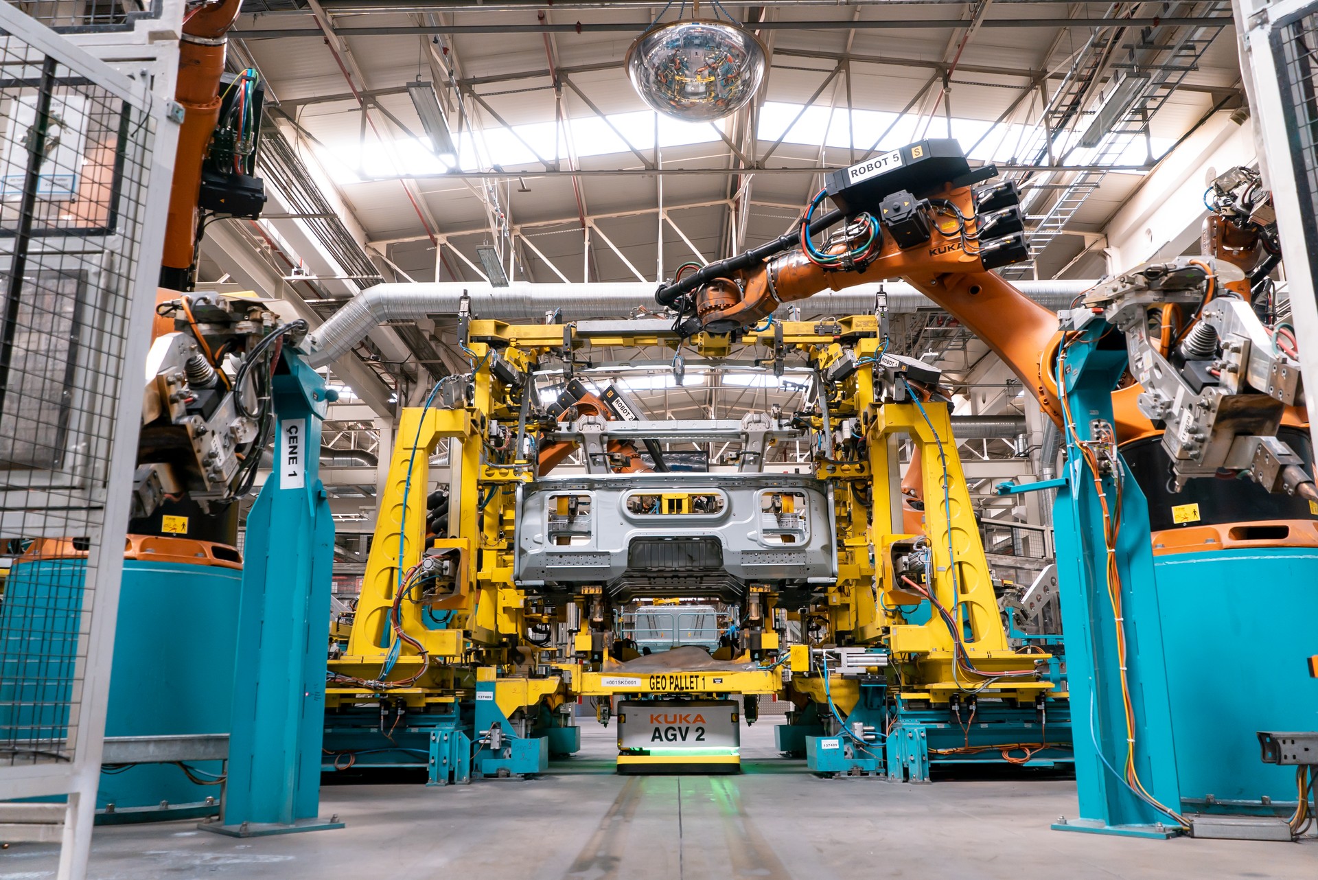 Mobile platforms transport truck cabins in and out of welding cell. (Source: Kuka Robotics)