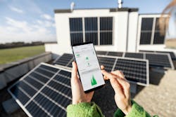 Woman monitors energy production from the solar power plant with mobile phone Woman monitors energy production from the solar power plant with mobile phone