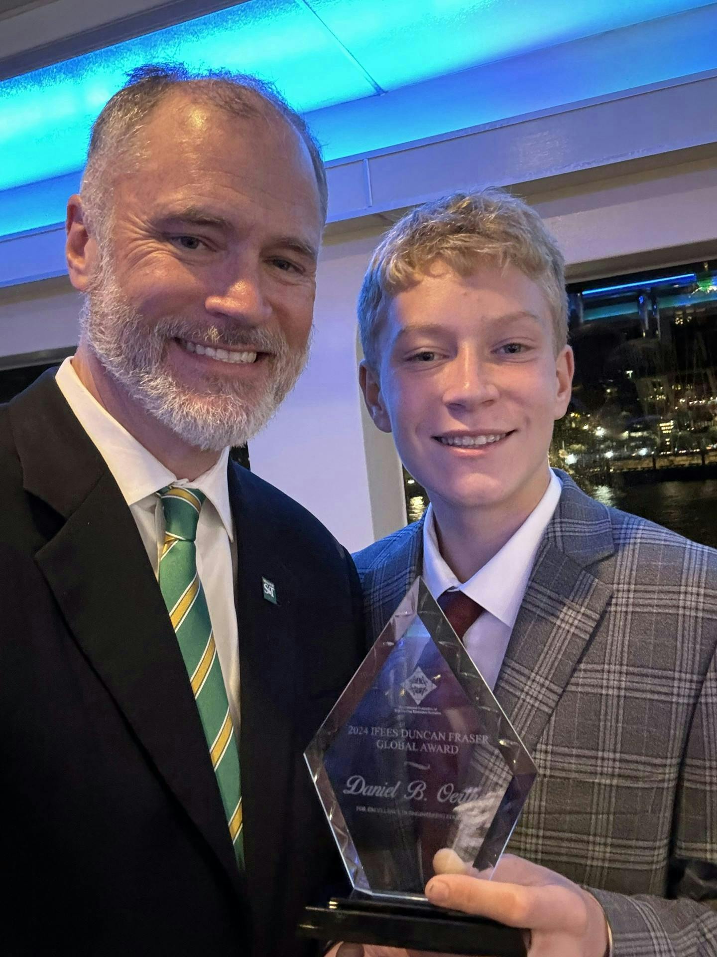 Figure 1: Dr. Daniel Oerther, left, holds his award with his son, Barney.