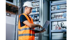 Adult electrician builder engineer testing and screwing equipment in fuse box and repairing of modern electricity power station Adult electrician builder engineer testing and screwing equipment in fuse box and repairing of modern electricity power station