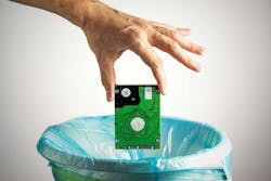 Person's hand throws a computer hard disk into the trash bin Person's hand throws a computer hard disk into the trash bin