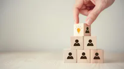 Hand flips cube with icon light bulb and human symbol