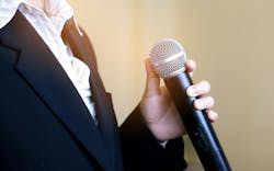 Woman speaking into a microphone Woman speaking into a microphone