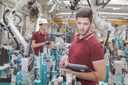 two engineers check functionality while commissioning a production line in welding shop two engineers check functionality while commissioning a production line in welding shop