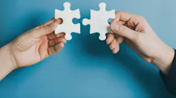 Hands bringing puzzle pieces together