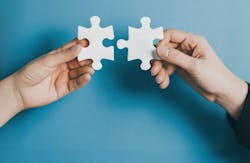 Hands bringing puzzle pieces together Hands bringing puzzle pieces together