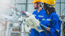 Engineers team mechanic using computer controller Robotic arm for welding steel in steel factory workshop. Industry robot programming software for automated manufacturing technology