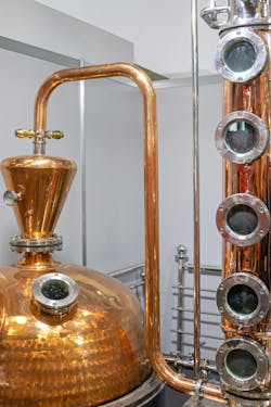 Figure 1: A distillation column with trays or packing provides greater performance separating alcohol from water than simple boiling methods. This sample is far fancier-looking than a typical industrial unit. Figure 1: A distillation column with trays or packing provides greater performance separating alcohol from water than simple boiling methods. This sample is far fancier-looking than a typical industrial unit.