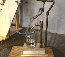Figure 9: Measuring final distillate percentage uses a hydrometer in a “parrot” to maintain a continuous reading. Figure 9: Measuring final distillate percentage uses a hydrometer in a “parrot” to maintain a continuous reading.