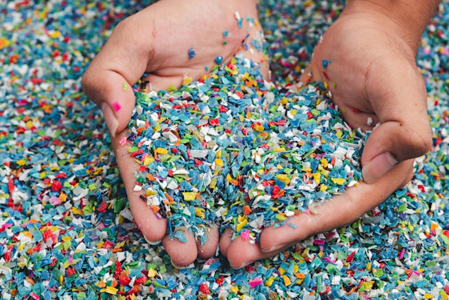 Cupped handfuls of multi-colored plastic pieces