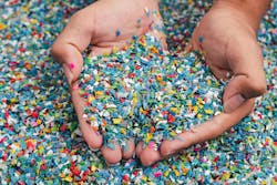 Cupped handfuls of multi-colored plastic pieces Cupped handfuls of multi-colored plastic pieces