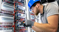 Electrician in switchboard room. Cable installation. Wiring work.