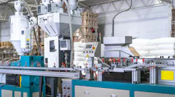 Industrial plastic extrusion machine in modern factory, automated production line with control panel, pneumatic system and material feeders, plastic processing equipment for manufacturing