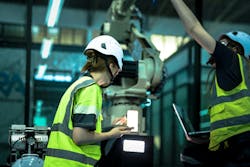 A robotics engineer uses a tablet to program a robot with a machine vision system, while her colleague calibrates the end-of-arm tooling on another unit in a system integration lab. A robotics engineer uses a tablet to program a robot with a machine vision system, while her colleague calibrates the end-of-arm tooling on another unit in a system integration lab.