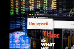 Honeywell company logo on a website with blurry stock market developments in the background, seen on a computer screen through a magnifying glass. Honeywell company logo on a website with blurry stock market developments in the background, seen on a computer screen through a magnifying glass.