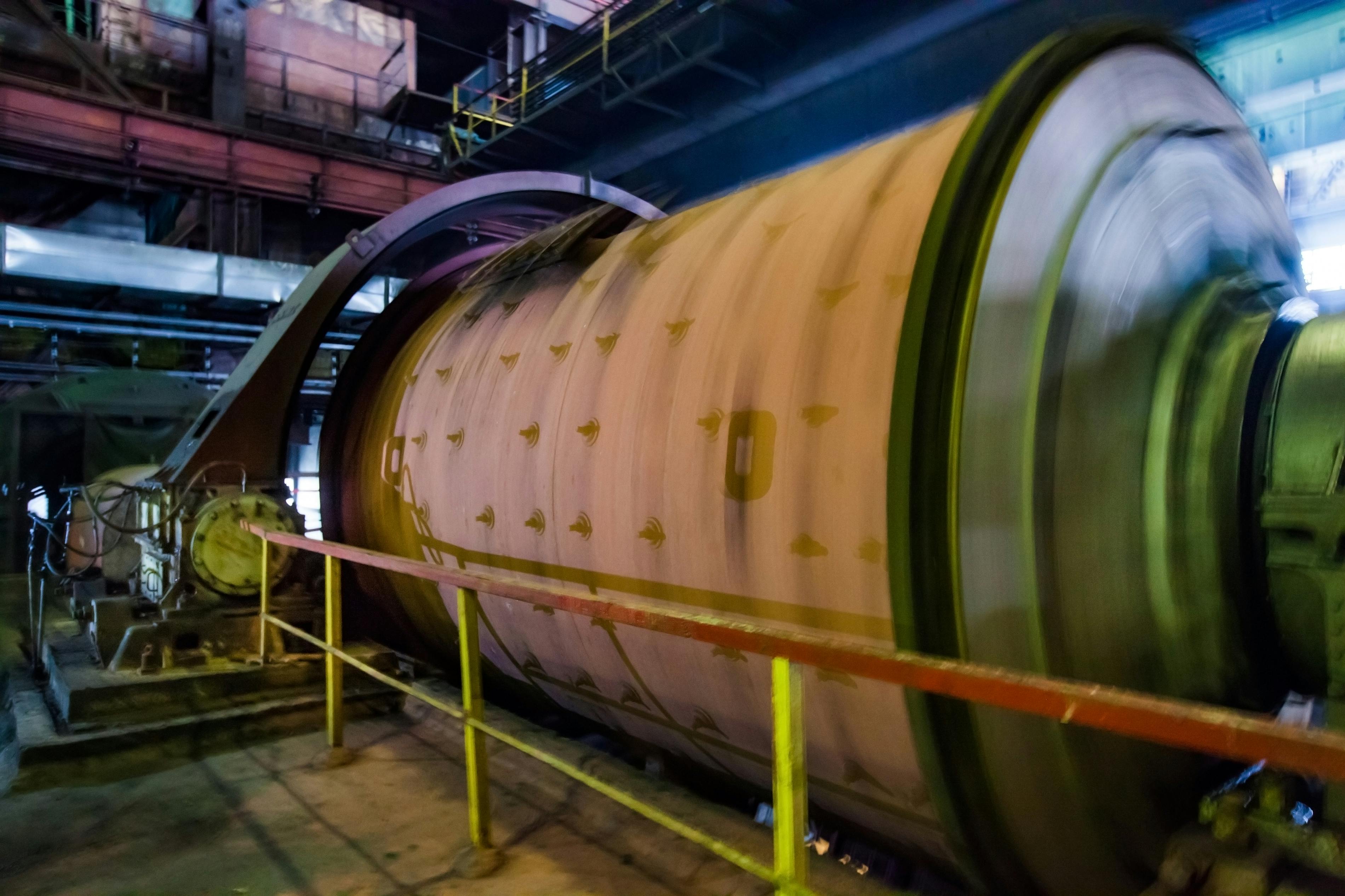 Industrial ball mill on the ore concentration plant. Motion blurred rotated drum.