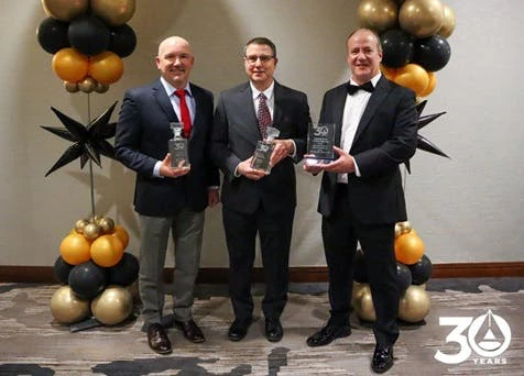 Cybertrol executives celebrate the company's 30th anniversary with commemorative plaques.