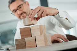 Start building your future from now. Shot of an unrecognisable businessman sitting alone in his office and using building blocks to plan. Start building your future from now. Shot of an unrecognisable businessman sitting alone in his office and using building blocks to plan.