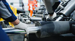 Worker mechanic check pipe system of hydraulic hose valves in industry machinery.