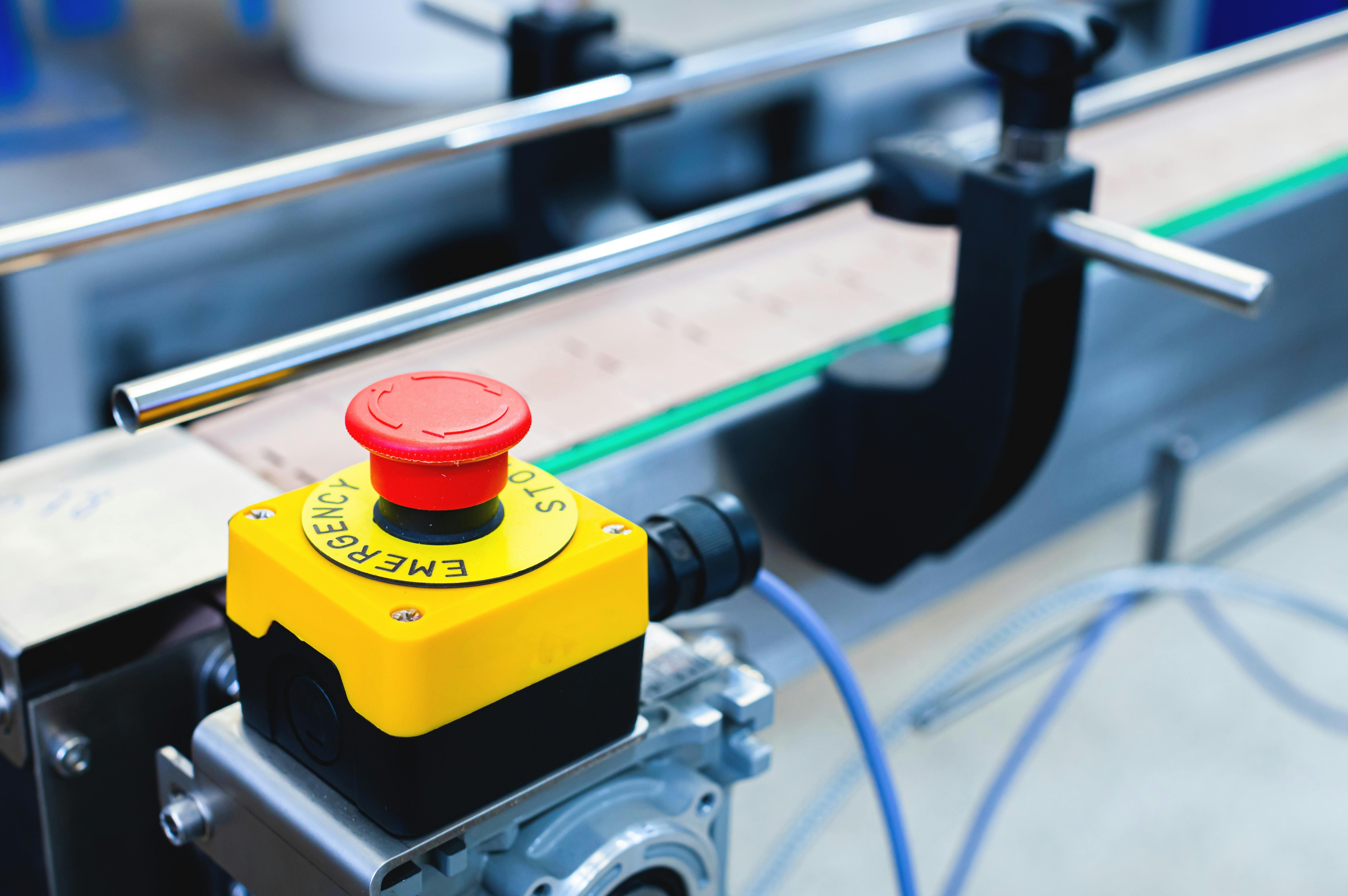 Simple red emergency stop button, Conveyor belt with empty cans. Production and preparation of conveyor equipment in the production of machines