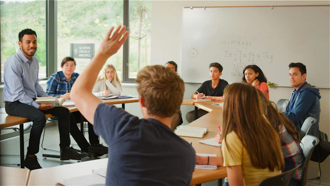 Male Student Asking Tutor Question Tutor In High School College Students Math Class