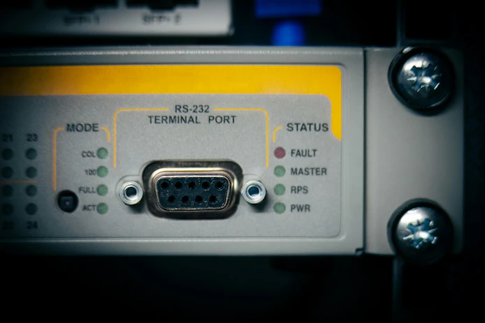 Close-up of RS-232 terminal port on a network switch with multiple status indicators