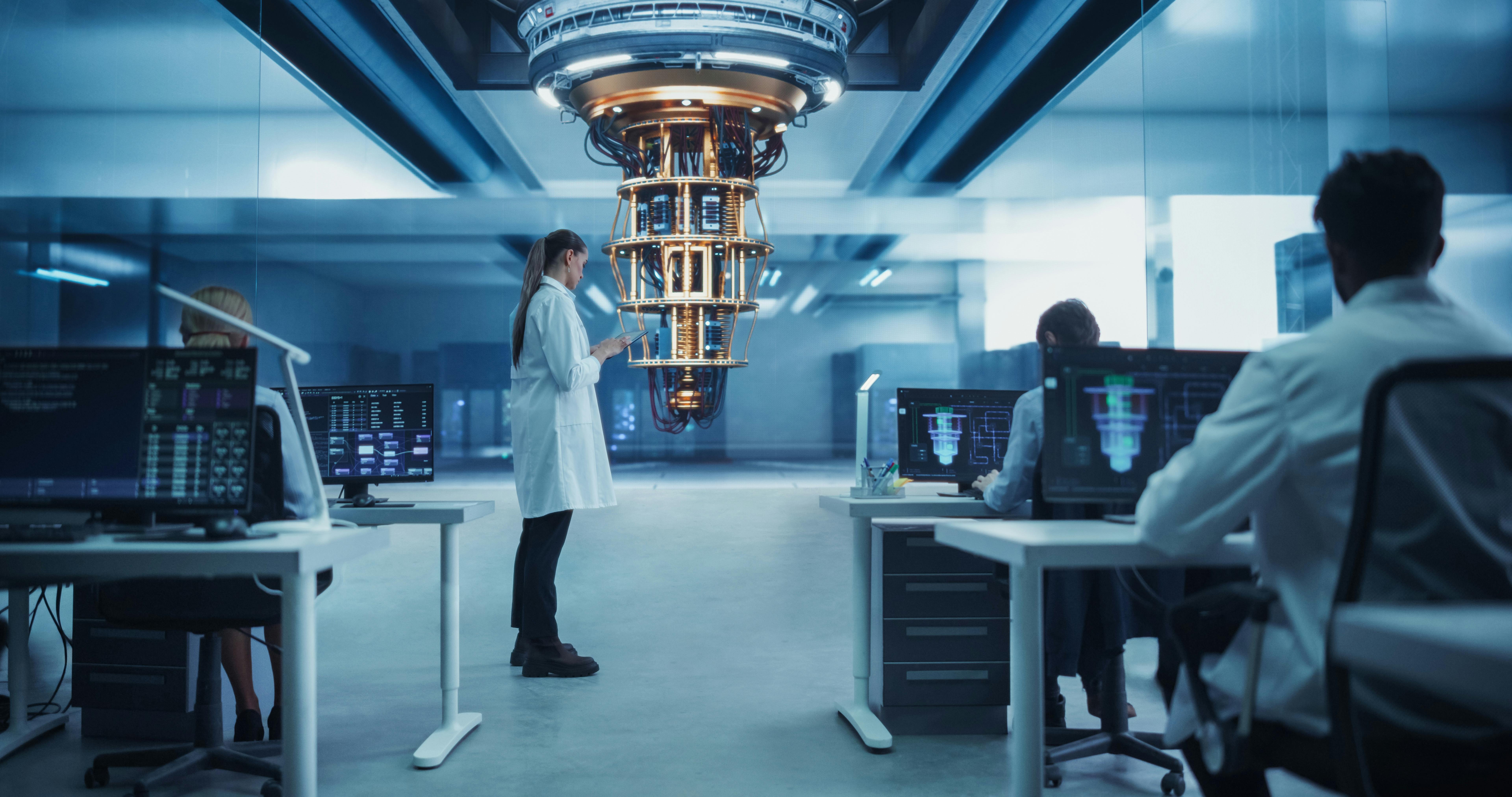Female Scientist Working on Quantum Computer Hardware, Using Tablet Computer to Access Technical Specifications and Control Processor Parameters. Group of Developers Work on AI Behind Their Desks