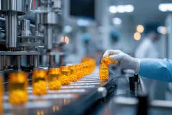 A gloved hand pours pills into a bottle on a conveyor belt in a pharmaceutical manufacturing facility. Multiple filled bottles are in a row. A gloved hand pours pills into a bottle on a conveyor belt in a pharmaceutical manufacturing facility. Multiple filled bottles are in a row.