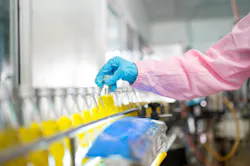 Female quality control inspector checking bottled fruit juice on production line in beverage factory, using tablet for monitoring and inspection Female quality control inspector checking bottled fruit juice on production line in beverage factory, using tablet for monitoring and inspection