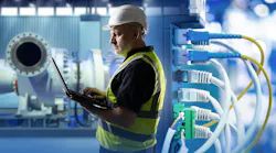 Industrial networking, equipment maintenance. Engineer uses laptop near network cables and machinery, monitoring systems and ensuring connectivity in production facility. Industrial networking, equipment maintenance. Engineer uses laptop near network cables and machinery, monitoring systems and ensuring connectivity in production facility.