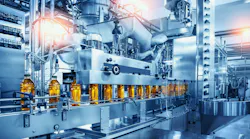 Conveyor belt with juice bottles on beverage factory interior in blue color.