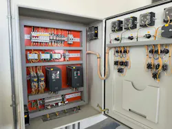 A meticulously organized industrial electrical control panel with its door open, revealing a complex network of wiring, circuit breakers, contactors, relays, and variable frequency drives (VFDs). A meticulously organized industrial electrical control panel with its door open, revealing a complex network of wiring, circuit breakers, contactors, relays, and variable frequency drives (VFDs).