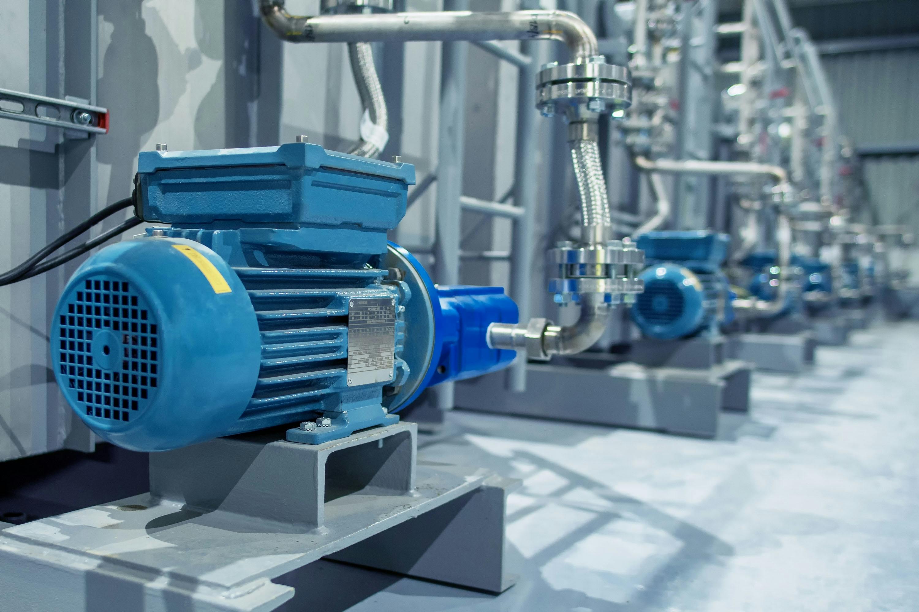 Industrial equipment. New blue electric motors with pumps on the stainless steel production line. Industrial background.. Additive pump station in petrochemical technology.