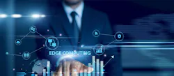Businessman using tablet analyzing edge computing and growth graph chart, real-time processing, IoT data, cloud integration, decentralized network performance, digital transformation insights.