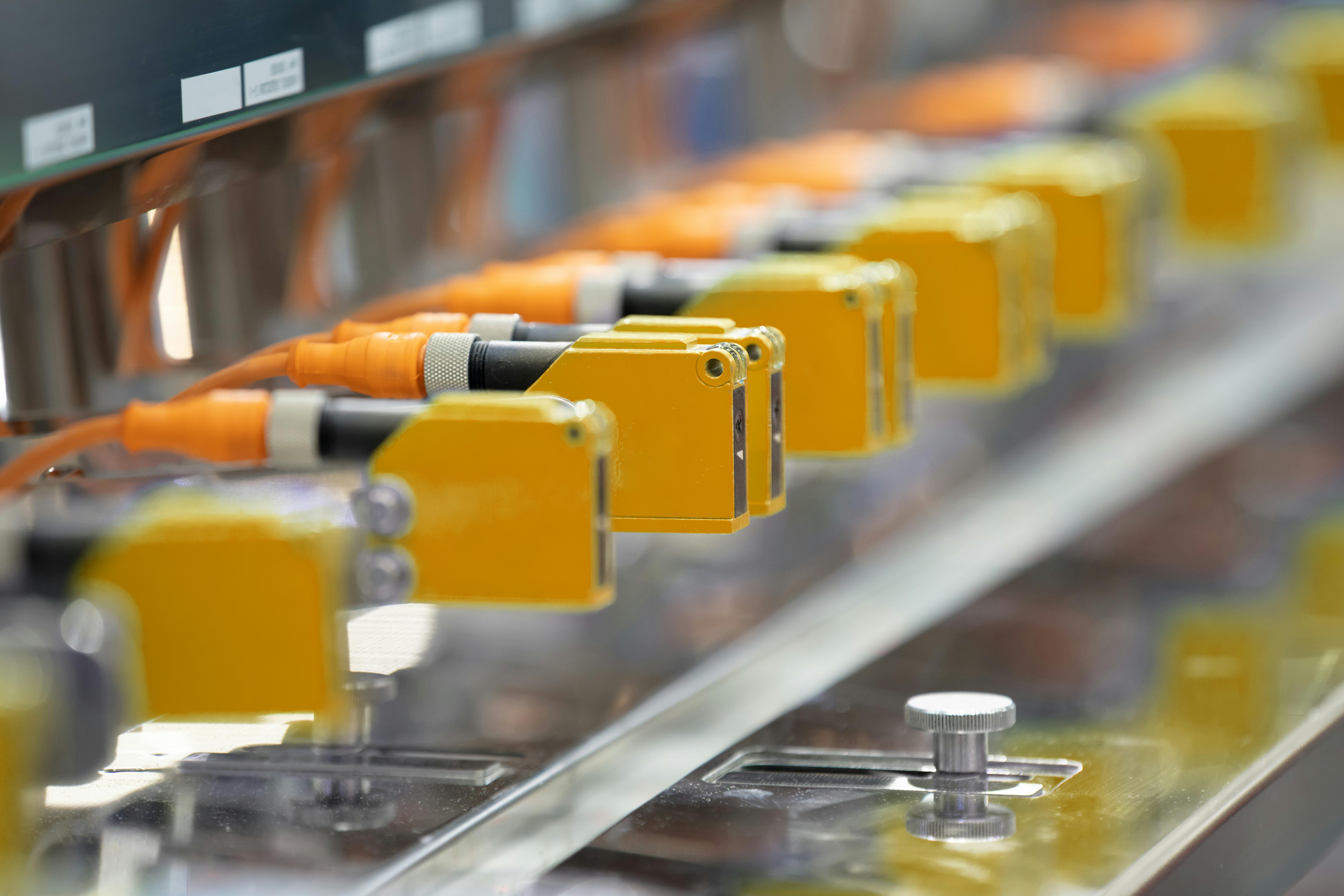 Photoelectric Sensor installed in a row of industrial machine in a factory..