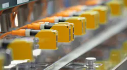 Photoelectric Sensor installed in a row of industrial machine in a factory..