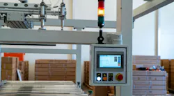 Industrial control panel with HMI display and signal tower on conveyor line