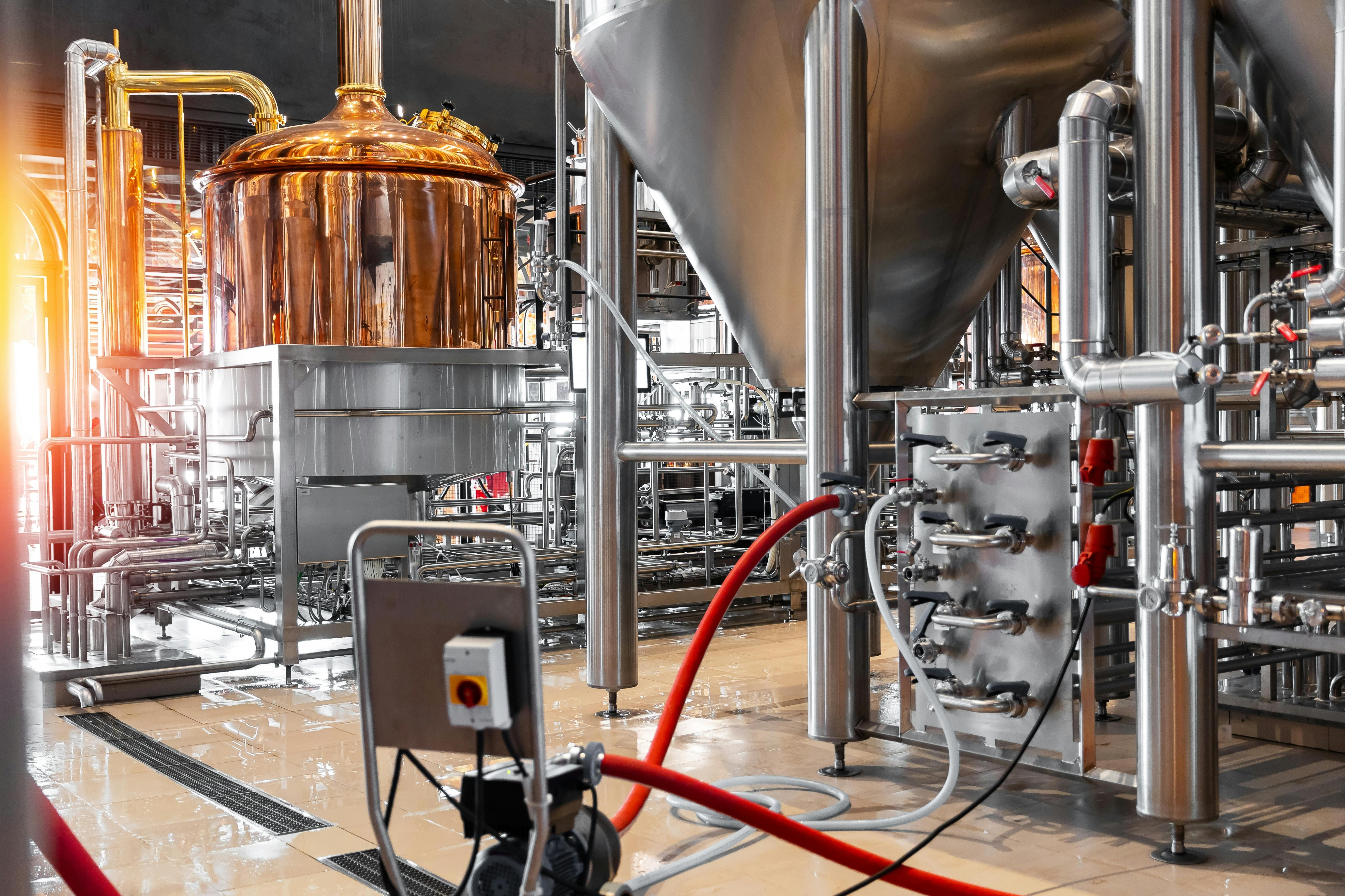 Pipes, stainless steel brewing equipment and large reservoirs or tanks in a modern beer factory.