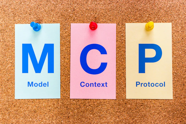 Three colored paper cards pinned to a cork bulletin board display the letters MCP (Model Context Protocol), illustrating the MCP standard for AI integration.