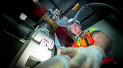 A robotics technician performs a critical repair on the joint of an industrial robotic arm, troubleshooting the servo motor and wiring during a system commissioning or maintenance cycle.